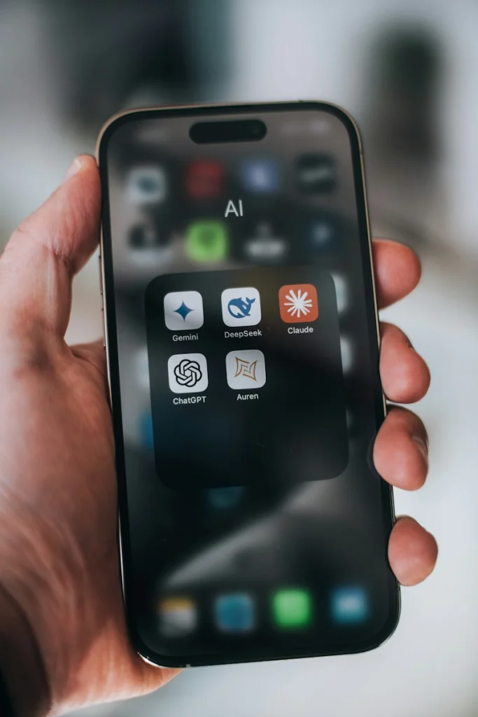 Hand holding a phone with ai application icons
